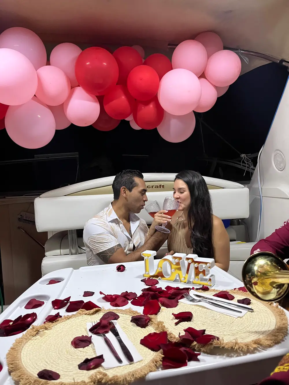 Pareja brindando en su cena romántica a bordo