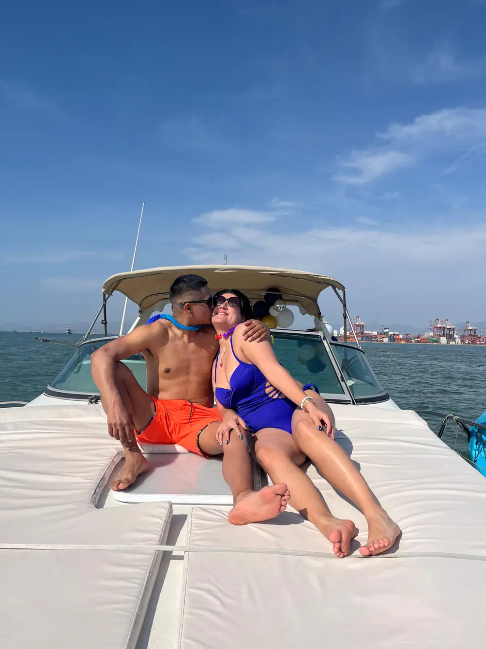 Pareja disfrutando del sol en la proa del yate